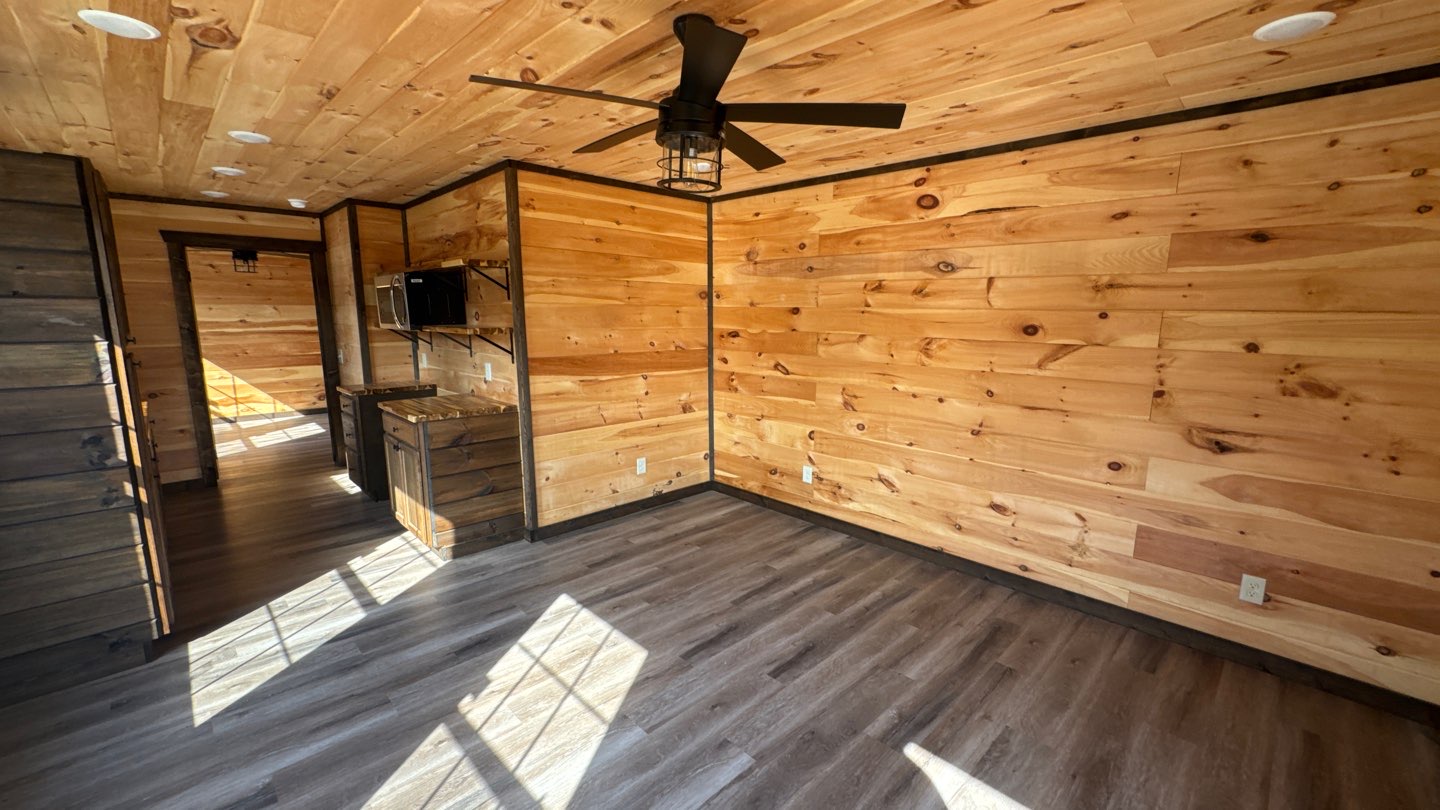 Barndominium interior with knotty pine walls and ceiling fan