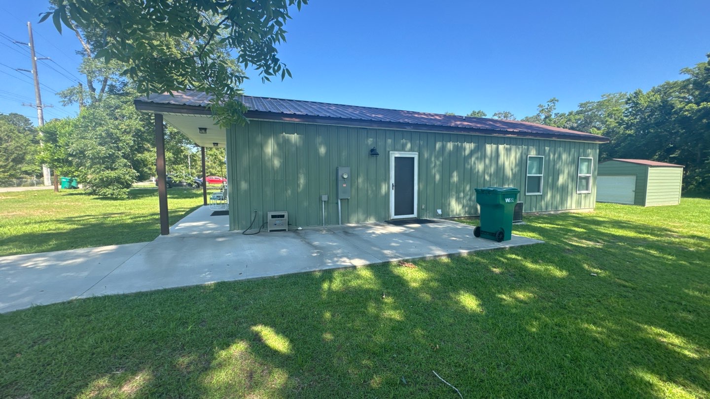Completed green metal building barndominium with covered porch in Northwest Florida