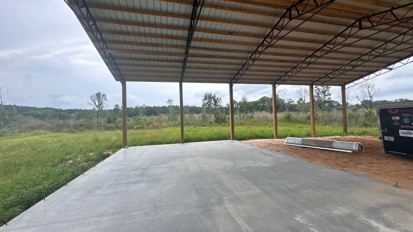 Pole barn metal roof structure over fresh concrete slab