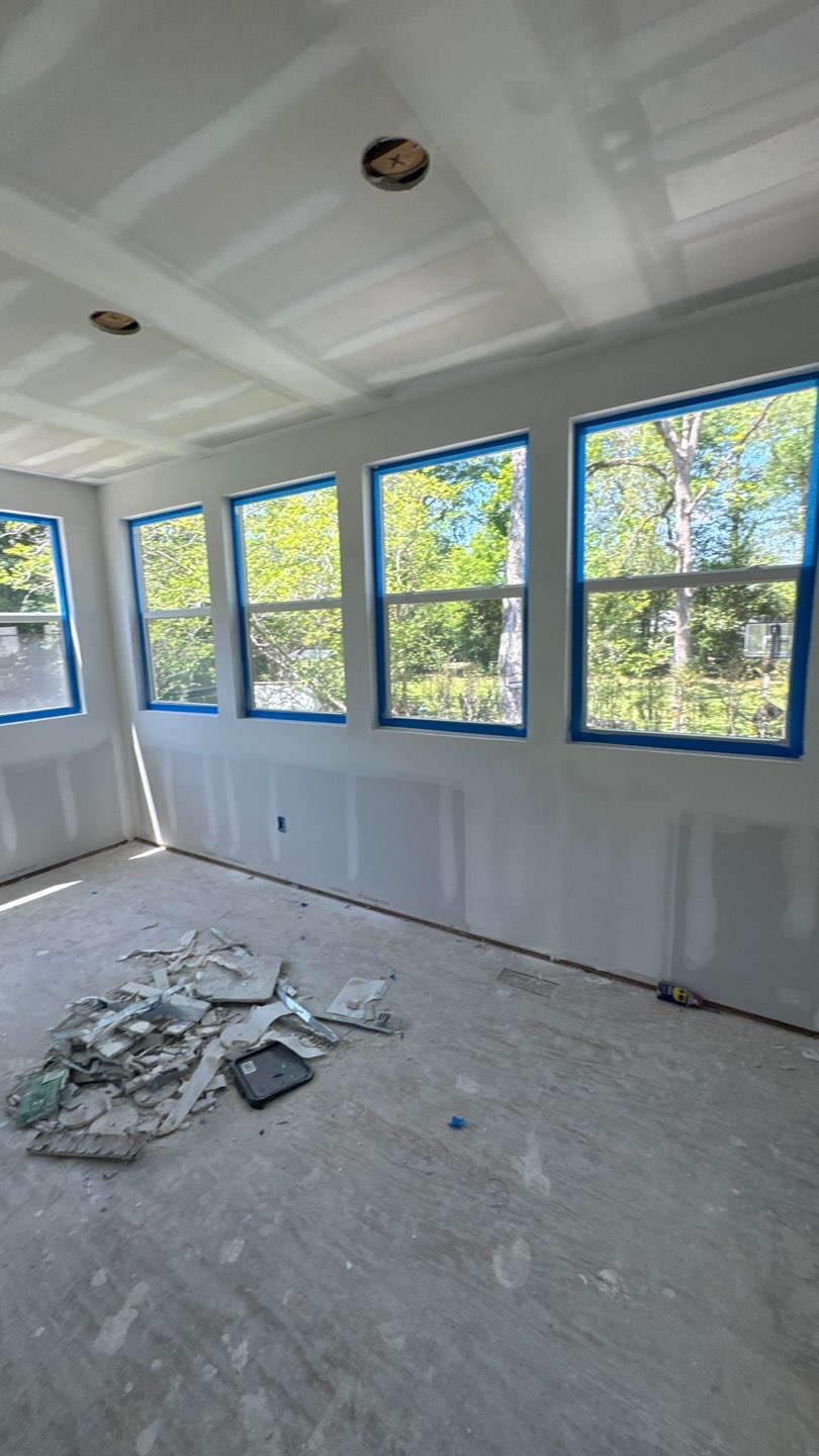 Sunroom addition interior with finished drywall and a full window wall during a whole-home renovation in Marianna, FL