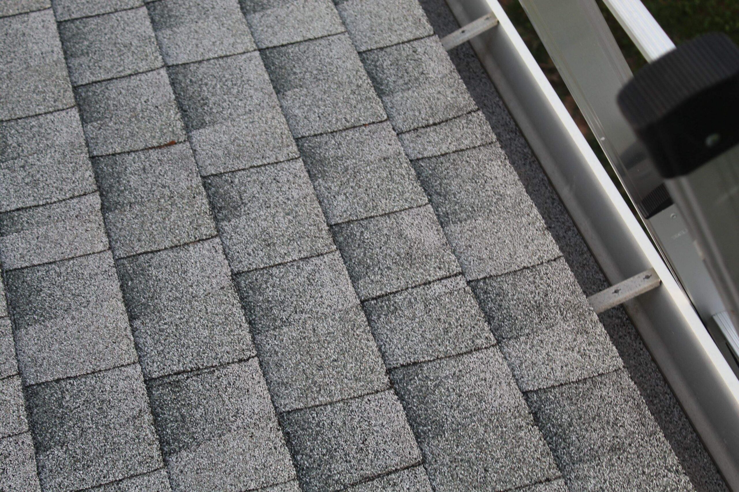 Finished gutter beside a shingle roof edge