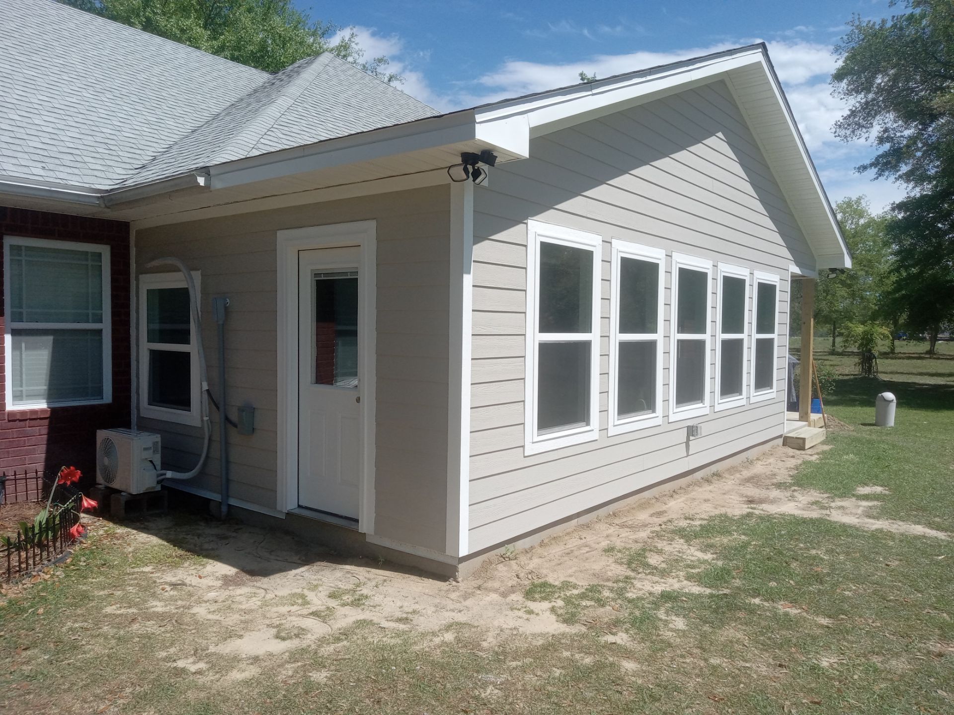 Florida room addition with Hardie board siding and a mini-split outdoor unit