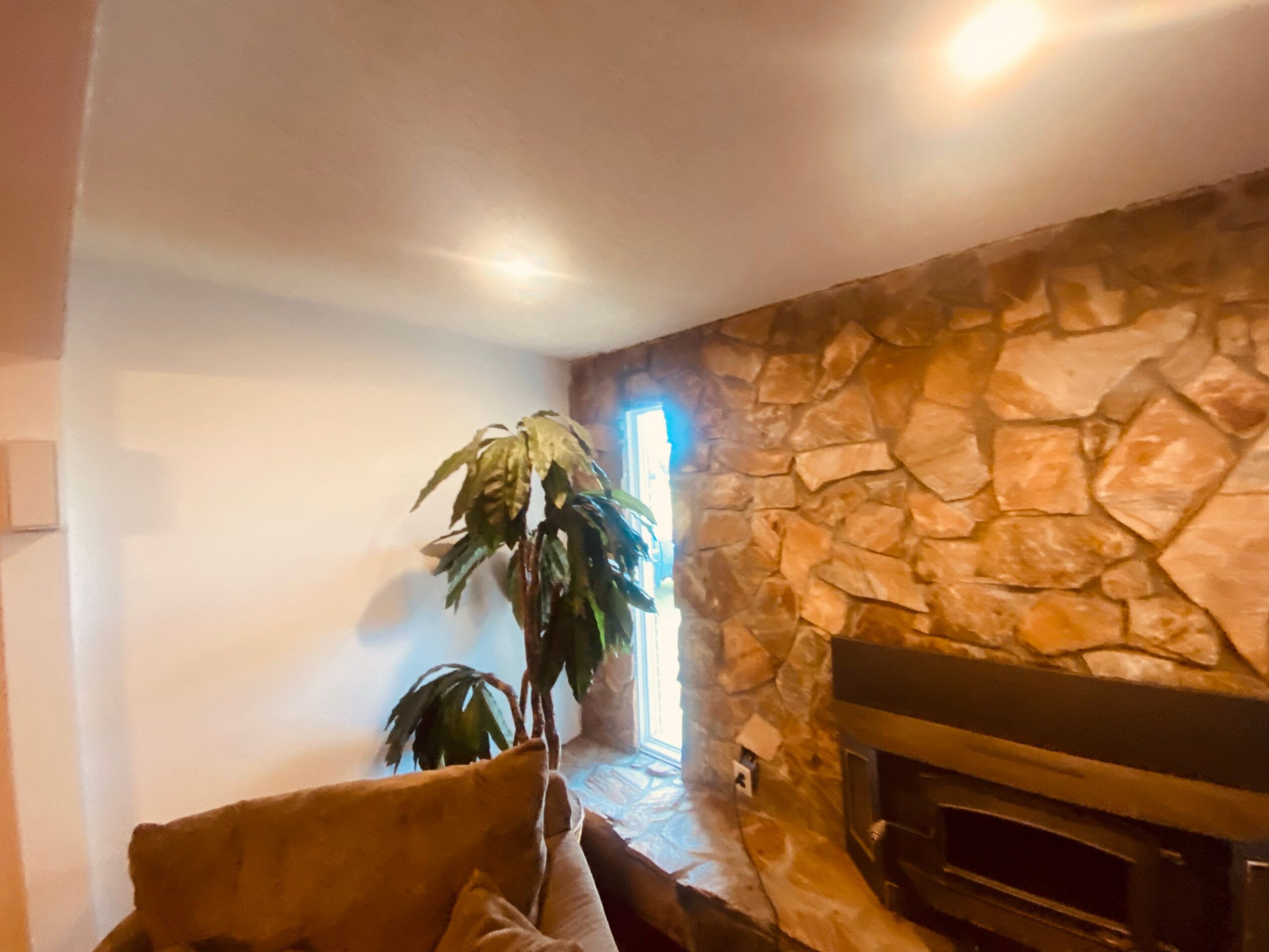 Recessed ceiling lights beside a stone fireplace