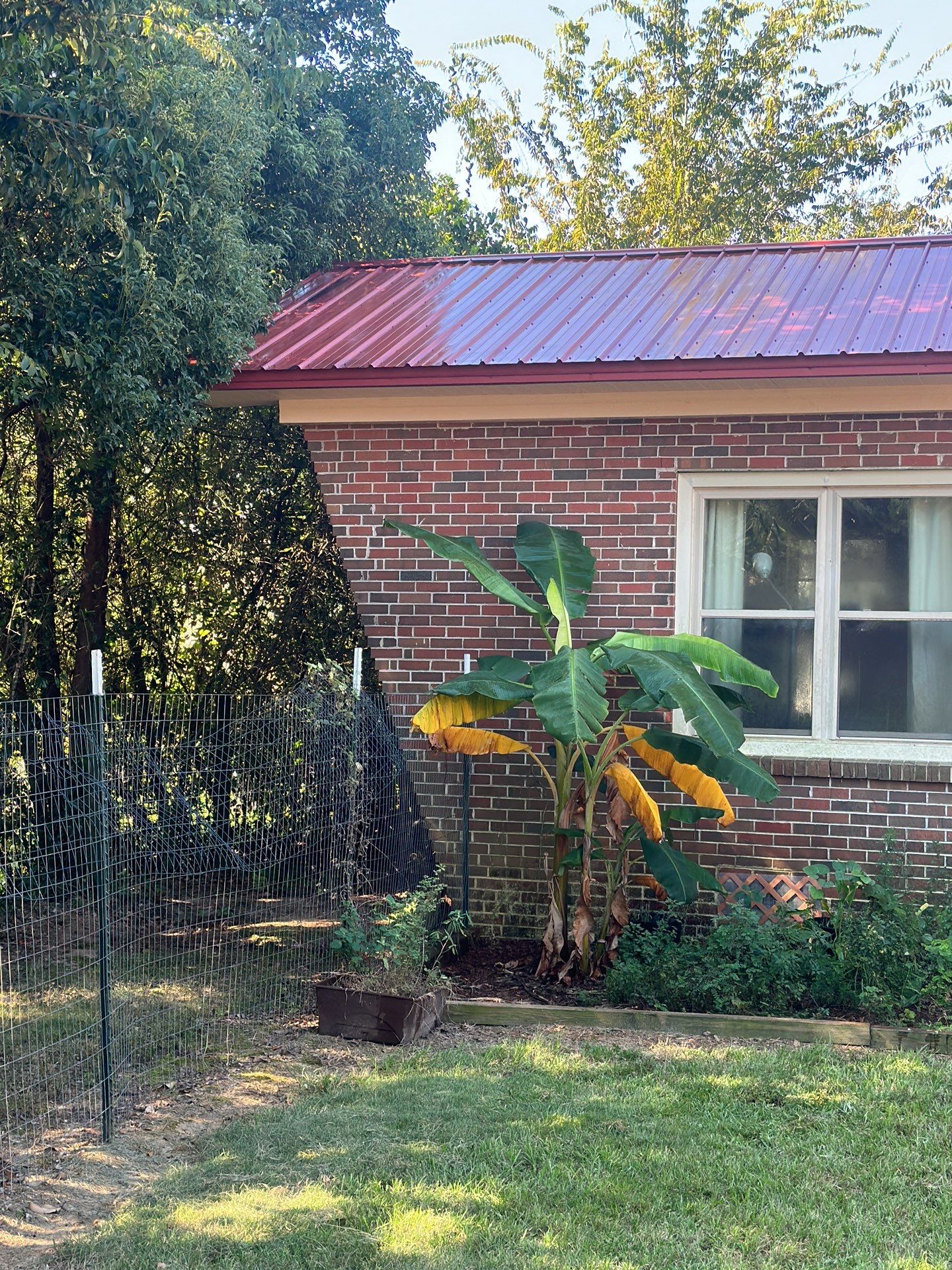 Red metal roof over a brick exterior