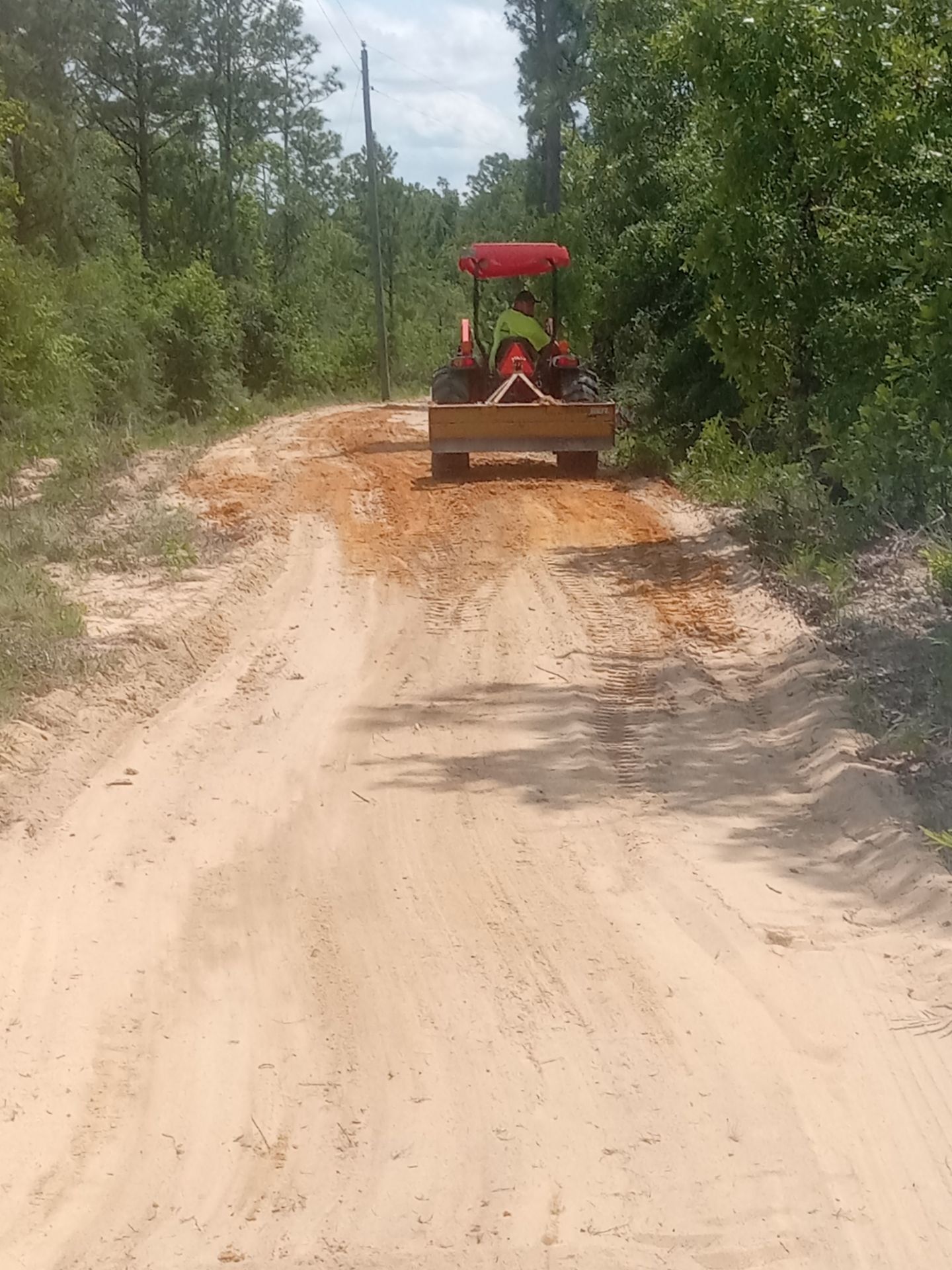 Tractor grading an unpaved road