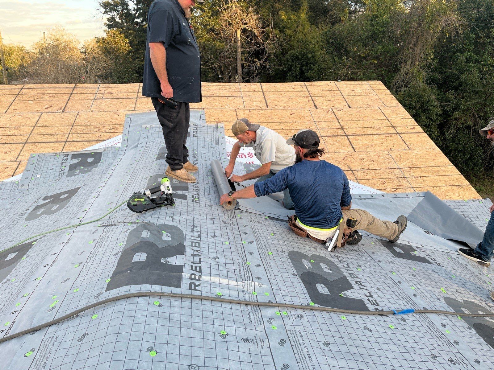 Roofing crew positioning underlayment