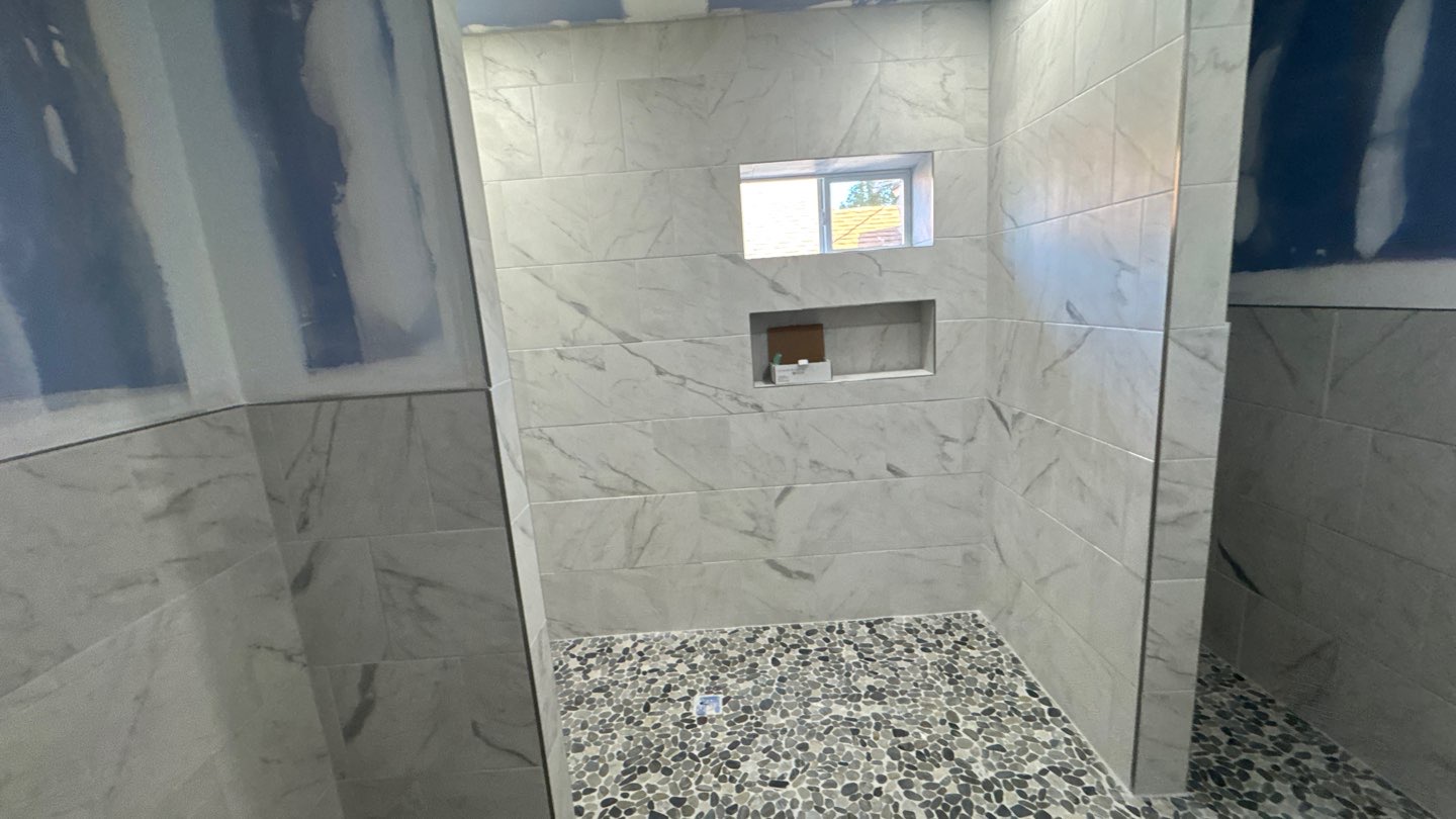 Shower tile, niche and pebble floor during installation