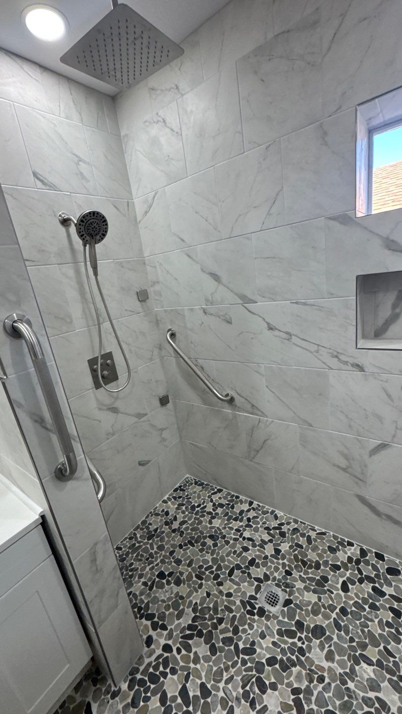 Tiled shower with handheld fixture and grab bars