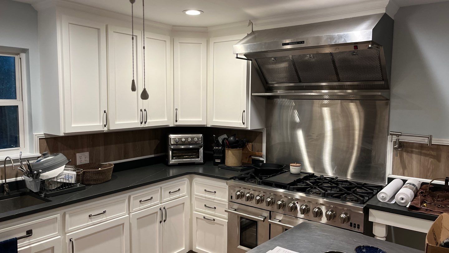 White kitchen cabinetry and stainless cooking area